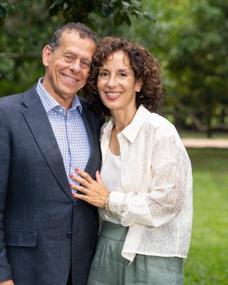Manny and Adriana Gonzalez standing together outdoors under a tree